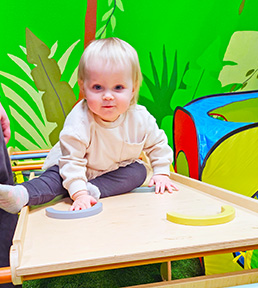 Toddler sitting on wooden gym